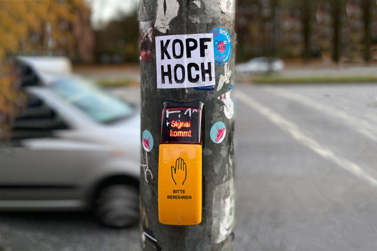 Aufkleber Kopf Hoch an einer Fußgängerampel
